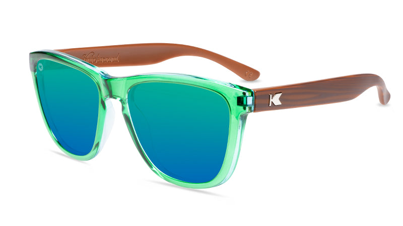 Sunglasses with glossy green fronts, wooden arms and polarized green lenses, flyover